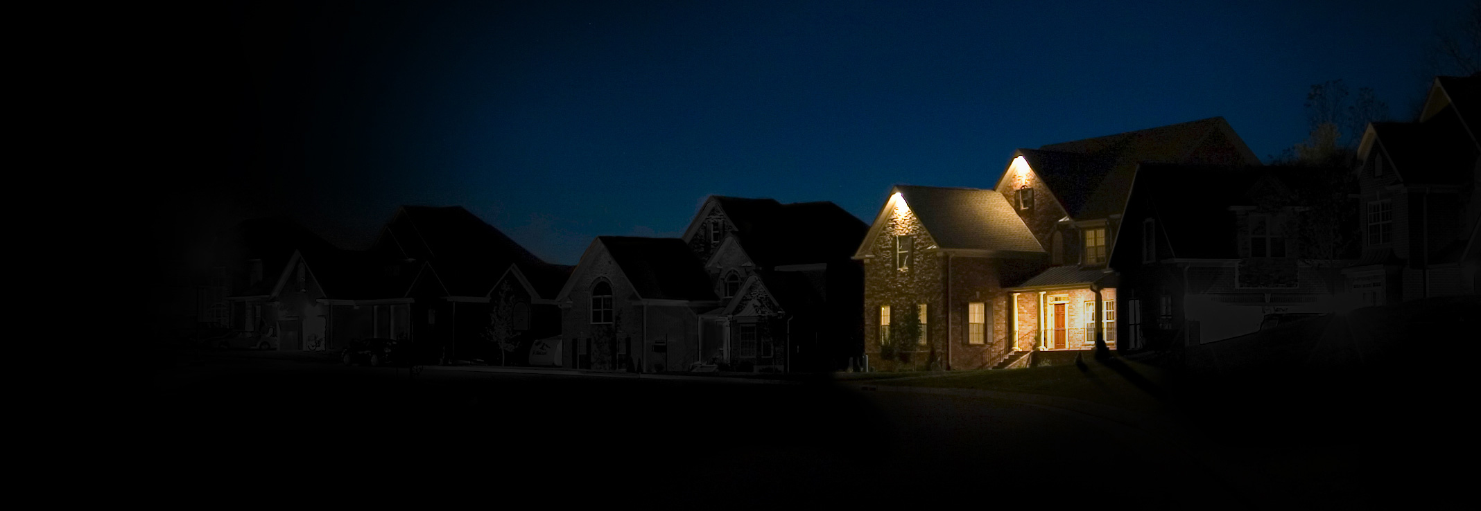 A home with backup generator power during an outage while the neighborhood is dark.