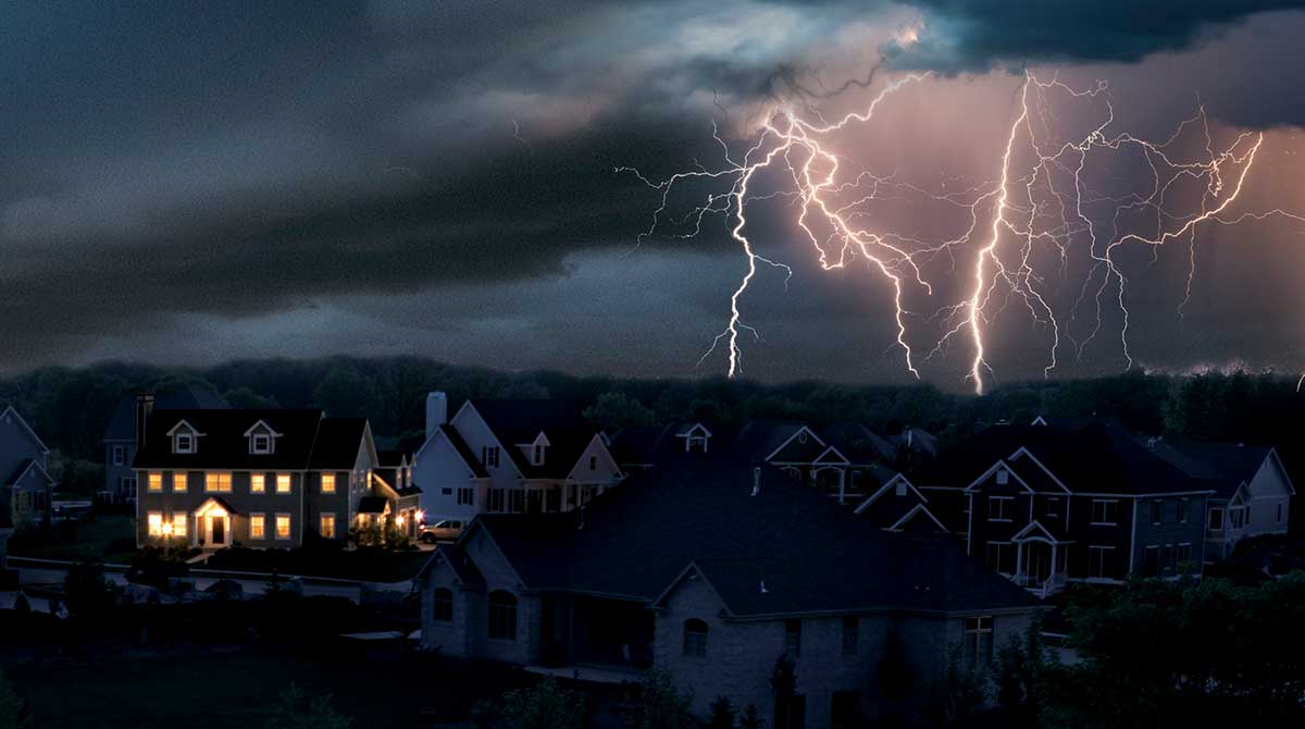 Lightning Flashes over a suburb where the only house with lights has a whole house generator.