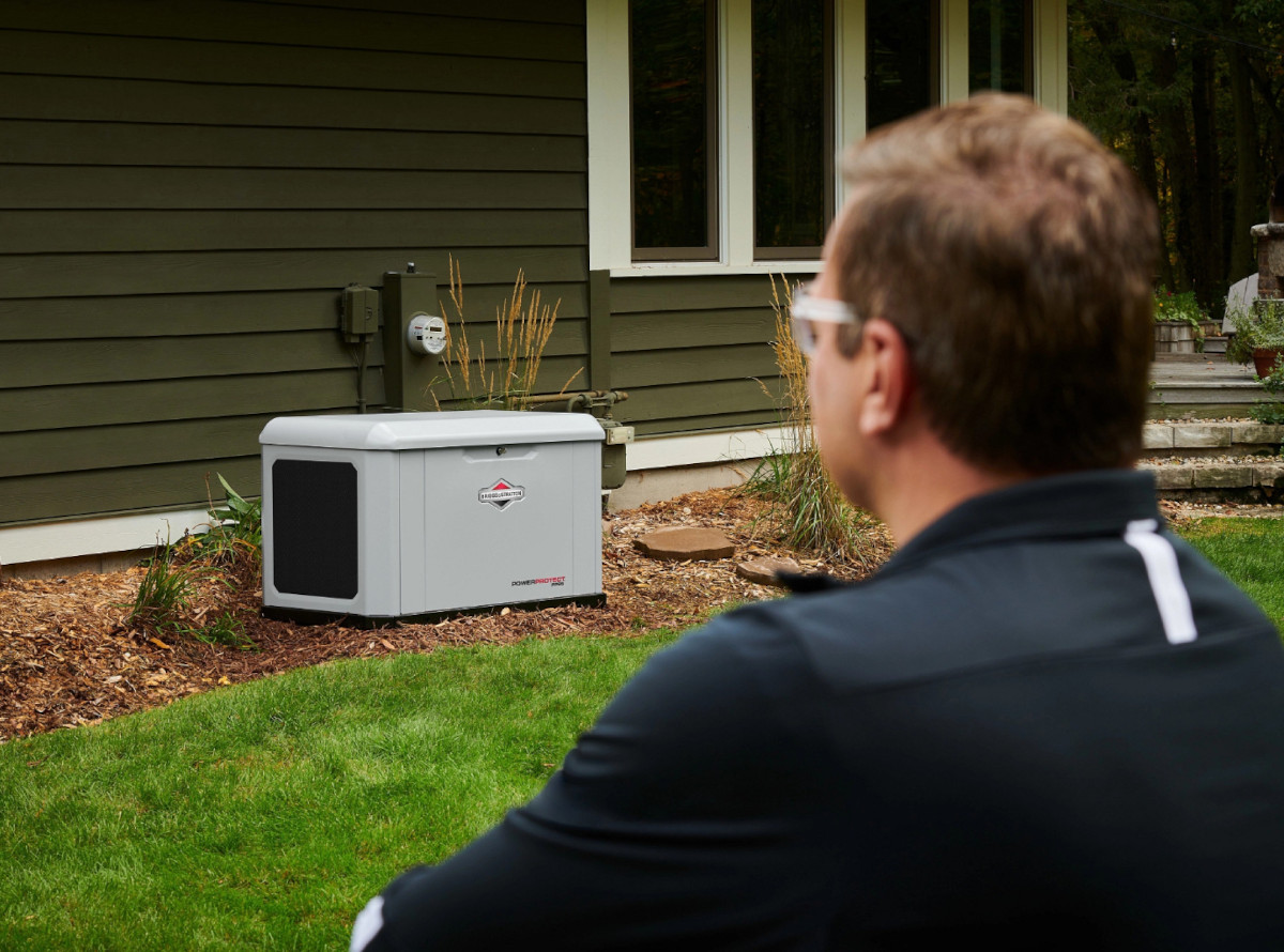 A homeowner looks at his newly installed 26kW Briggs and Stratton generator in his back yard.